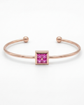 Rose gold bracelet with a pink gemstone on a white background