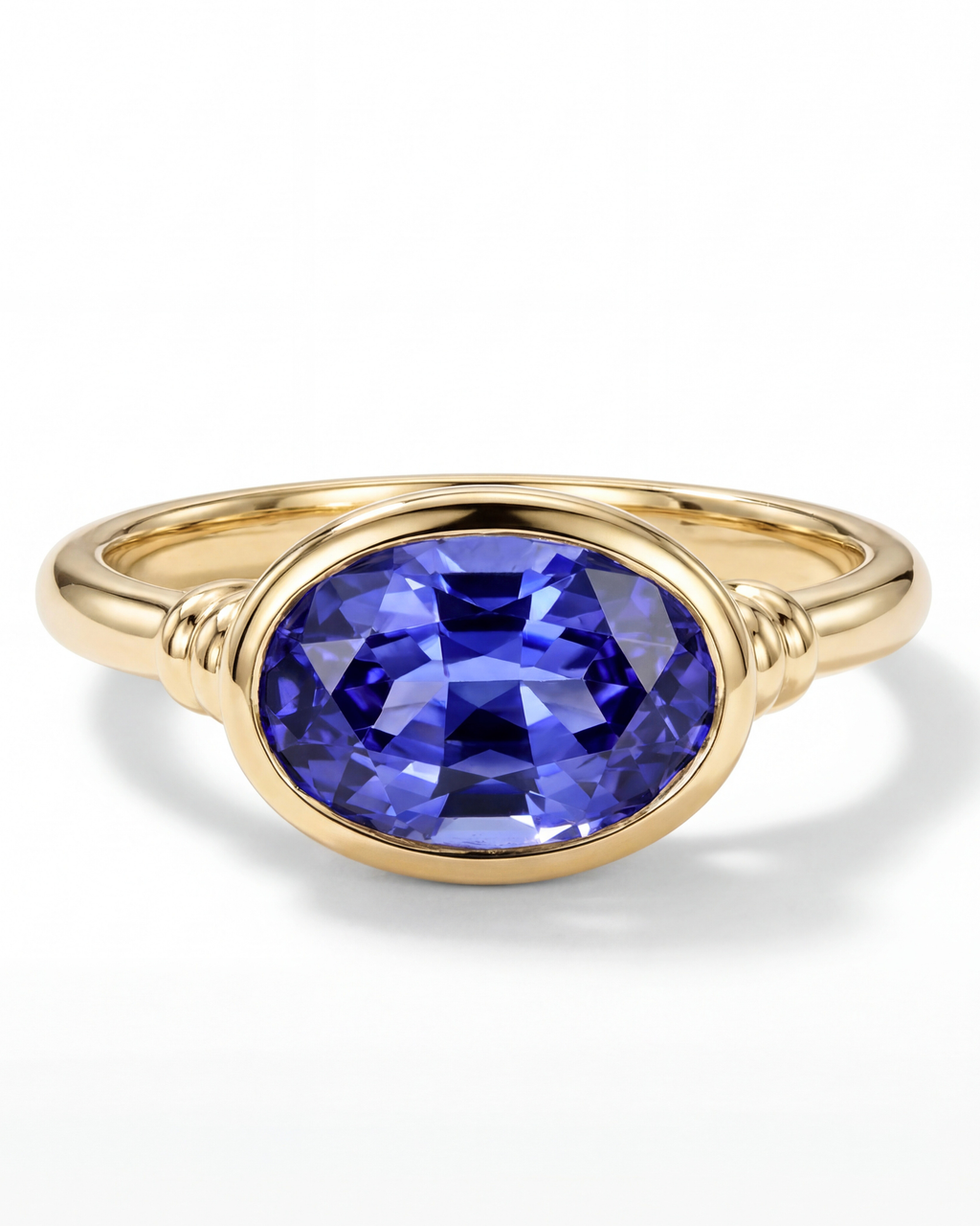Gold ring with a blue gemstone on a white background