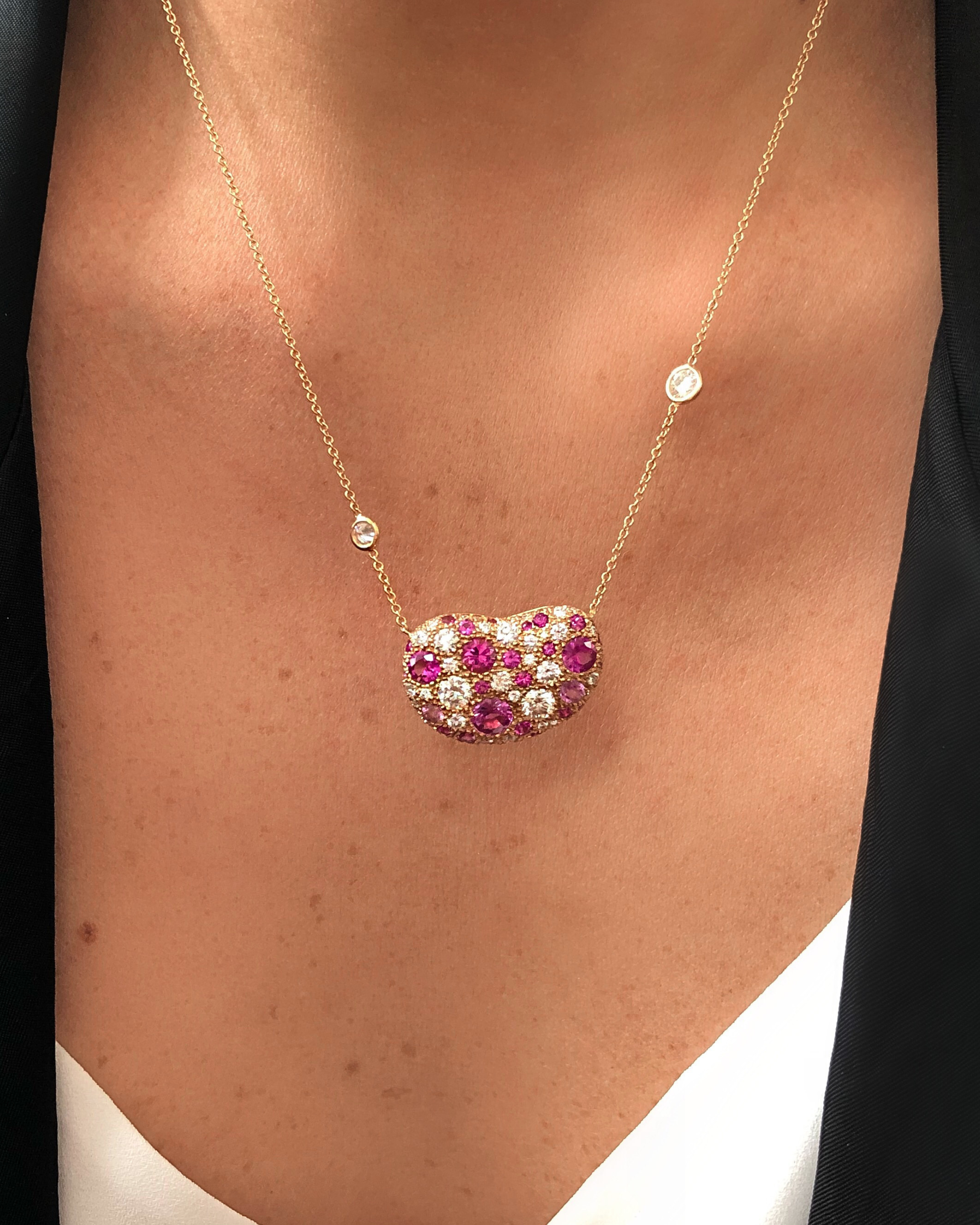 Necklace with a heart-shaped gemstone pendant on a person's neck