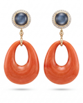 Pair of earrings with orange hoop designs and blue gemstones on a white background