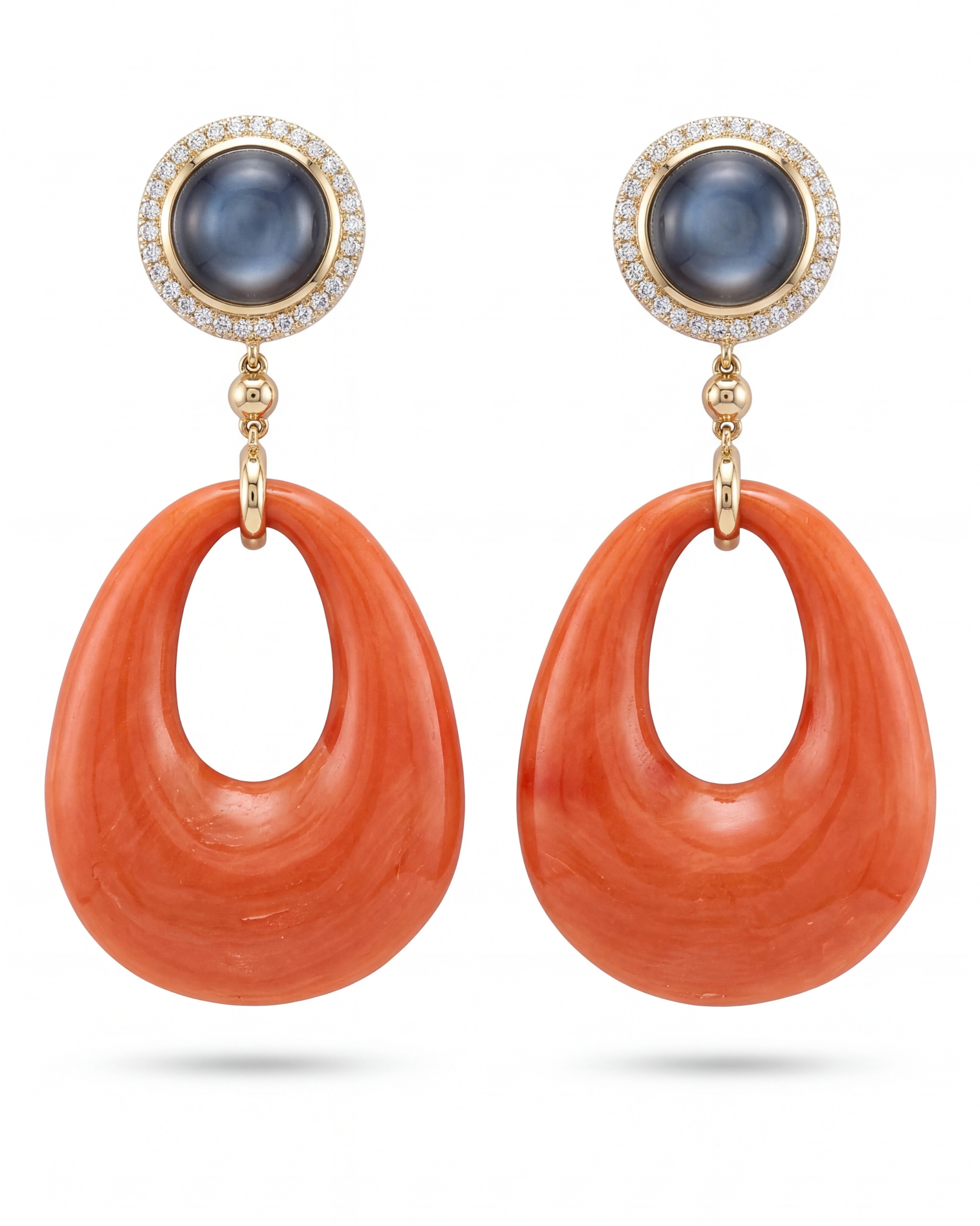 Pair of earrings with orange hoop designs and blue gemstones on a white background